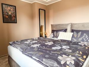 a bedroom with a bed with a black and white blanket at Chalet mit 2 Einheiten, Garten, Terrasse & Garage in Blankenburg