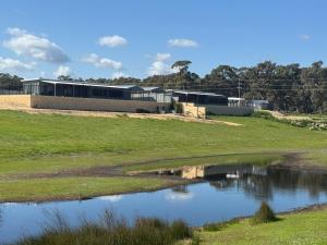 a building next to a pond in a field at Tyrooki at Castlemoore Unit 1 in Guilderton