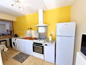 a kitchen with yellow walls and a white refrigerator at Charmante maison de vacances à Chauffayer - 4 pers - Aubessagne - FR-1-393-184 in Chauffayer +9 photos