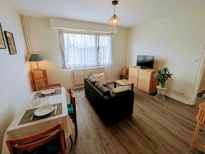un salon avec un canapé et une table dans l'établissement Appartement accueillant au cœur de Luxeuil-les-Bains proche thermes - FR-1-583-510, à Luxeuil-les-Bains