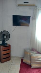 a bedroom with a fan and a red rug at Apartamento in Belém