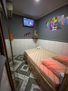a bedroom with a bed and a tv on the wall at Hotel jardim paulista in São Paulo