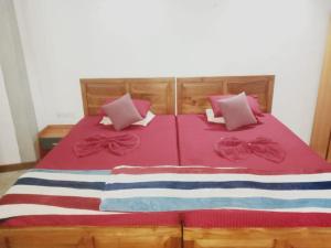 a bed with pink and blue blankets and pillows at Thehideout kurunegala in Kurunegala +7 photos
