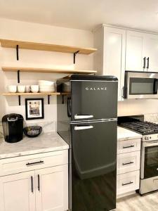 a kitchen with a black refrigerator and a microwave at Newly built Guest House near beaches in Costa Mesa