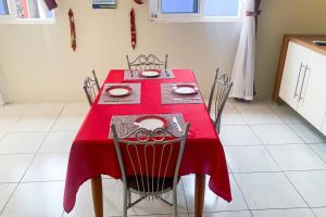 a red table with chairs and a red table cloth at Guest Favorite - Central - Gated - 2 Bedrooms in Willemstad