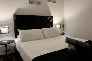 a bedroom with a bed with a black headboard and two lamps at PH Palermo Hostel in Buenos Aires +46 photos