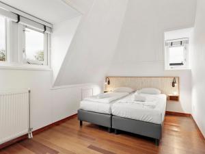 a bedroom with a bed and two windows at Comfortable Waterfront Park Retreat in Midlaren