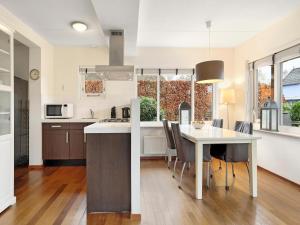 a kitchen and dining room with a table and chairs at Comfortable Waterfront Park Retreat in Midlaren