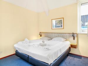 a bedroom with a large bed with white sheets at Waterfront Villa Near Groningen in Midlaren