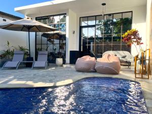 a swimming pool with two inflatable pillows next to a house at Tres Villas Kuta in Kuta Lombok