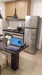 einen Laptop auf einem Tisch in der Küche in der Unterkunft APARTAMENTO DE LUJO en HERA TOWER in La Playa Bejarano