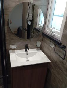 ein Badezimmer mit einem weißen Waschbecken und einem Spiegel in der Unterkunft APARTAMENTO DE LUJO en HERA TOWER in La Playa Bejarano