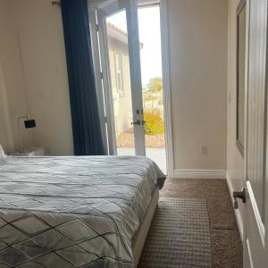 a bedroom with a bed and a sliding glass door at Golf course & Mountain view in West Wendover