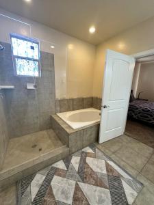 a bathroom with a tub and a shower with a glass door at Golf course & Mountain view in West Wendover +24 photos