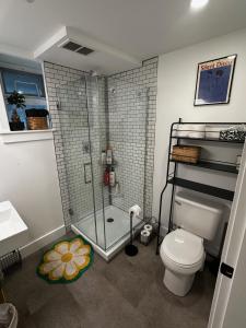 a bathroom with a shower and a toilet and a sink at The Orange Door Bungalow- 2-BR w private yard, walkable to cafes & restaurants, 10 min to DT in Vancouver +43 photos