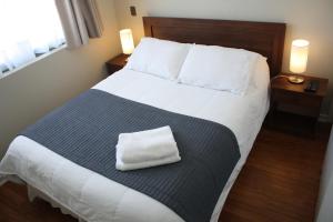 a bedroom with a large bed with a towel on it at Hostal Buró in Concepción