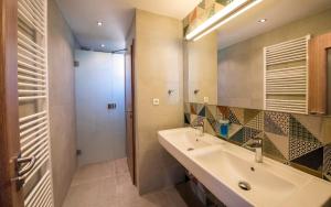 ein Bad mit einem Waschbecken und einem Spiegel in der Unterkunft Guesthouse Cyprian in Ždiar