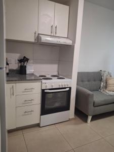 uma cozinha com fogão forno ao lado de um sofá em Excellent Monoambiente em Santos Lugares mais 2 fotografias