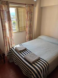 a bedroom with a bed with two towels on it at Cómodo departamento centrico a metros de la Catedral in San Fernando del Valle de Catamarca