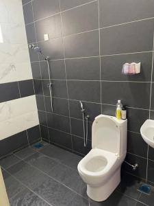 a bathroom with a toilet and a sink at The Indah Homestay Gerik in Gerik