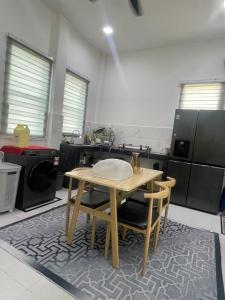 a kitchen with a wooden table and some appliances at The Indah Homestay Gerik in Gerik
