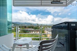 Ban KathuにあるA Stylish Condo in Local Area Kathu, Phuketの景色を望むバルコニー(テーブル、椅子付)