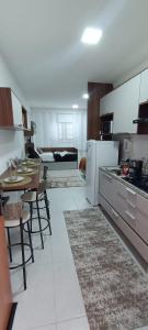 eine Küche mit einem Tisch und eine Küche mit einem Esszimmer in der Unterkunft Studio Nossa Senhora Aparecida - Condominium of Faith in Cachoeira Paulista