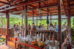 a group of people sitting at tables in a restaurant at Nui Tuong Village Stay in Tân Phú