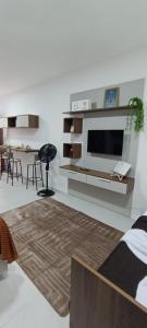 ein Wohnzimmer mit einem Flachbildfernseher an der Wand in der Unterkunft Studio Nossa Senhora Aparecida - Condominium of Faith in Cachoeira Paulista