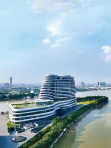広州市にあるVignette Collection The Xanadu Guangzhou, an IHG Hotelの川沿いの街並みに面した大きな建物
