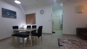 a dining room with a table and chairs and a clock at Cozy Homey in Pancur