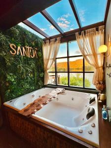 a large bath tub in a room with a large window at Santuá - Cabana Bellagio in Rio dos Cedros +54 photos