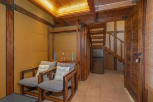 a room with two chairs and a ladder at Opatan Art Villa - Sukawati, Gianyar, Bali in Sukawati