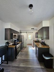a kitchen with wooden floors and stainless steel appliances at Cozy 3BR Cottage Near Headlands in Mentor
