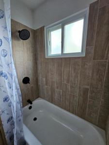 a bath tub in a bathroom with a window at Cozy 3BR Cottage Near Headlands in Mentor +16 photos