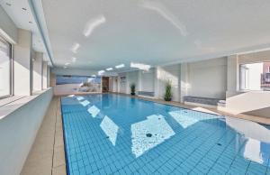 a large swimming pool with a blue tile floor at Terrassenhaus - 9 in Cuxhaven +13 photos