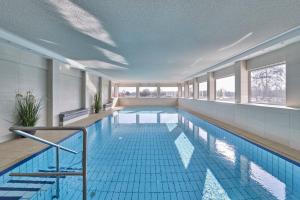 a large swimming pool with blue tiles in a building at Terrassenhaus - 9 in Cuxhaven