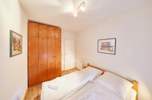 Un dormitorio con una cama y un armario de madera. en Knechtsand - 441, en Cuxhaven 22 fotos más