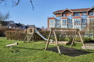 Un parque infantil con un tobogán frente a un edificio. en Knechtsand - 441, en Cuxhaven