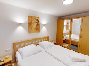 a bedroom with a white bed and a mirror at Knechtsand - 403 in Cuxhaven +15 photos