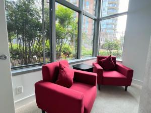 zwei rote Stühle und ein Tisch in einem Raum mit Fenstern in der Unterkunft The Tysons Corner Suite I 4 beds in Odricks Corner