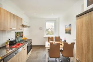 a kitchen with a table and chairs in a room at Strandhus Cuxi - 2 in Cuxhaven