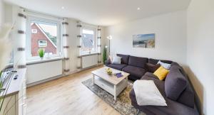 a living room with a couch and a table at Strandhus Cuxi - 2 in Cuxhaven