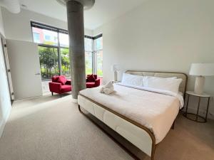 ein Schlafzimmer mit einem großen Bett und einem roten Stuhl in der Unterkunft The Tysons Corner Suite I 4 beds in Odricks Corner