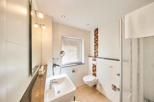 a white bathroom with a sink and a toilet at Residenz Seegras - 5 in Cuxhaven +13 photos