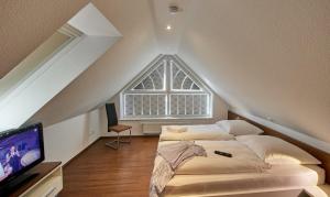 a attic bedroom with two beds and a tv at Residenz Seegras - 5 in Cuxhaven