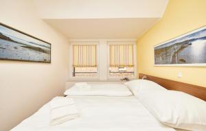 two beds in a room with two windows at Residenz Seegras - 5 in Cuxhaven