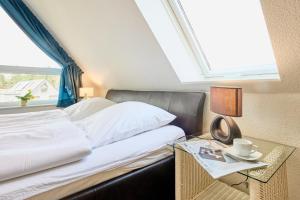 a bedroom with a bed with a table and a window at Strandburg - 12 in Cuxhaven