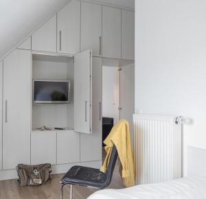 a bedroom with white cabinets and a chair at Hohe Lith - 335 in Cuxhaven