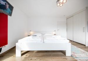 a white bedroom with a white bed in a room at Hohe Lith - 335 in Cuxhaven